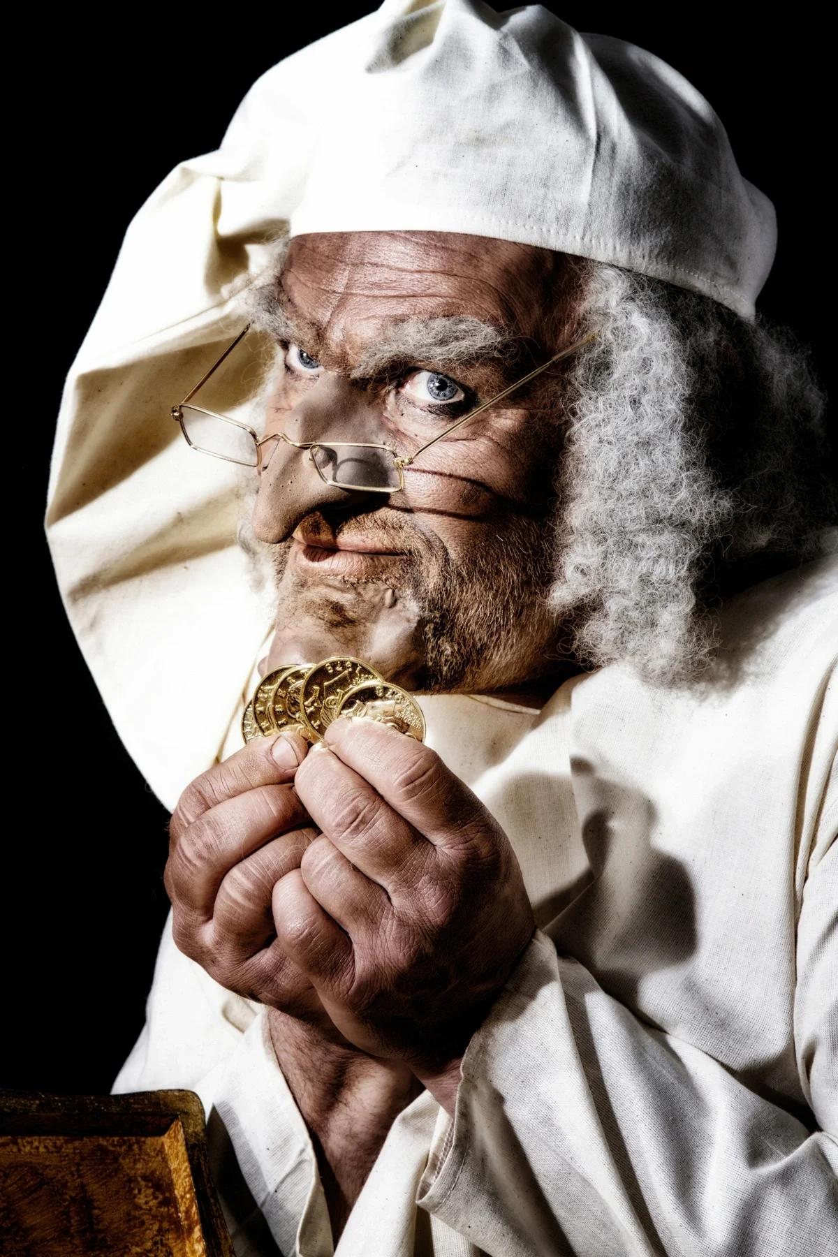 Scrooge clutching some gold coins