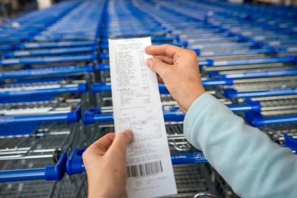 Image of someone holding a receipt in front of a row of shopping trolleys. Loyalty cards aren’t always the cheapest option. 6 fool-proof ways to save on your weekly food shop. Food bank referrals