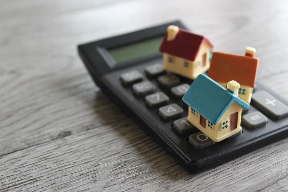Three model houses on top of a calculator