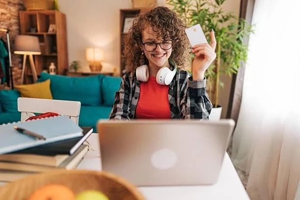 Image of someone online shopping with their credit card in hand. Shoppers could be owed hundreds as CMA looks at hidden online fees