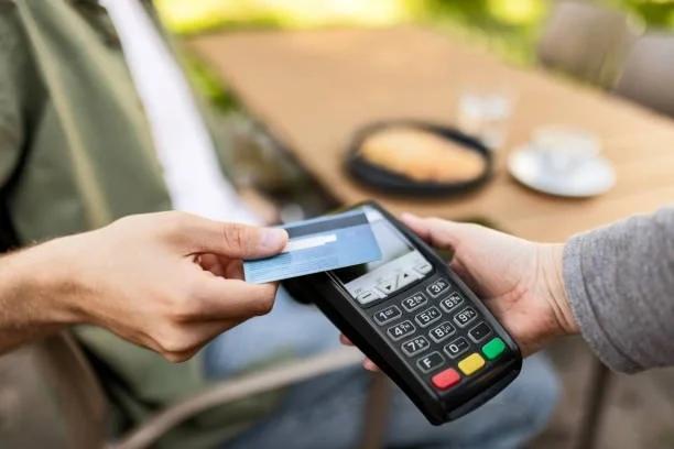 Image of someone paying on credit card. Credit card spending is on the rise