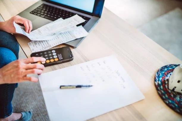 Image of a man surrounded by receipts and a calculator working out a budget. Why quiet debt is becoming a growing money problem. Why's everyone talking about quiet debt - and what you can do about it.