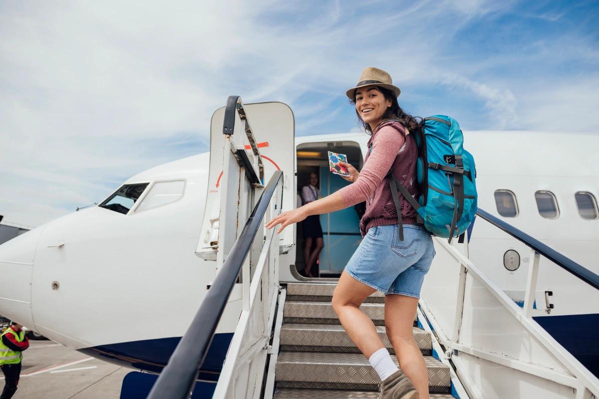 A smiling woman boarding an aeroplane