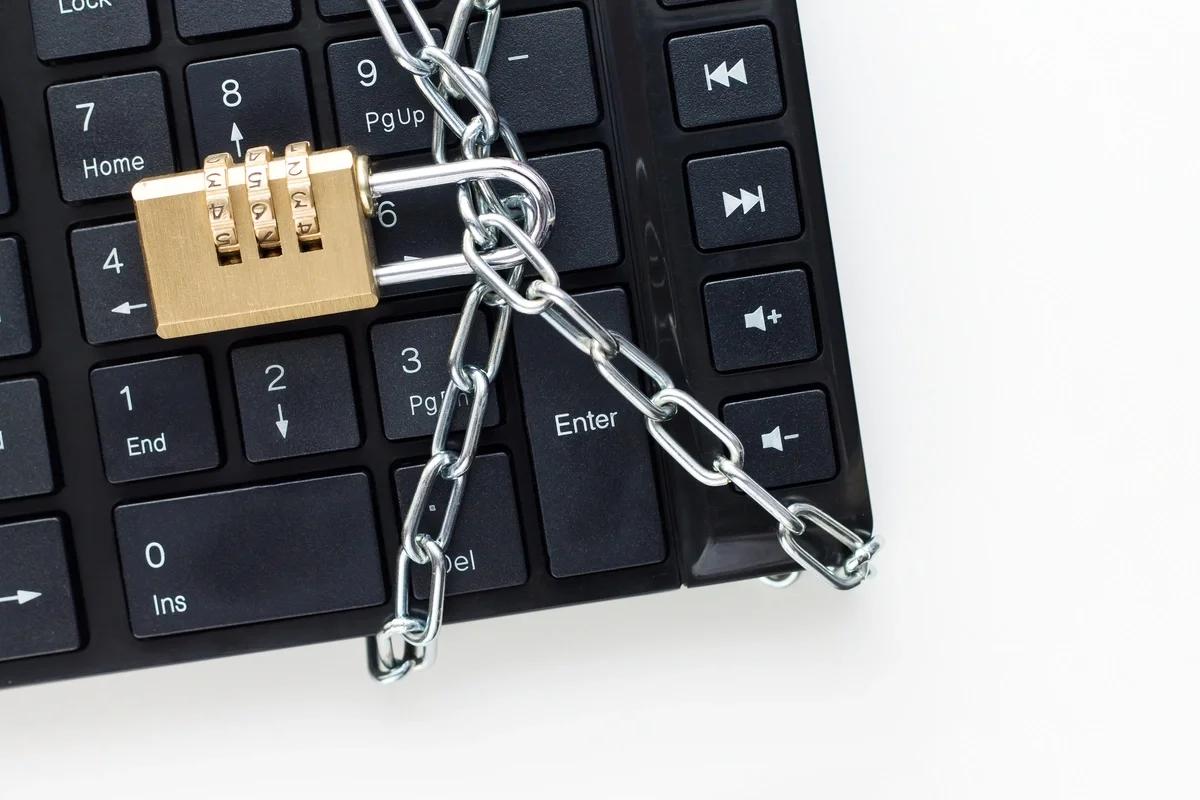 A computer keyboard wrapped in a chain and padlock