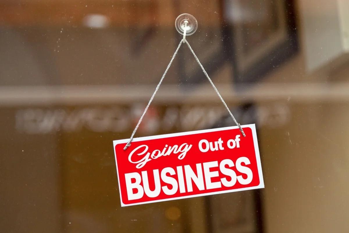A 'going out of business' sign hangs in a shop doorway