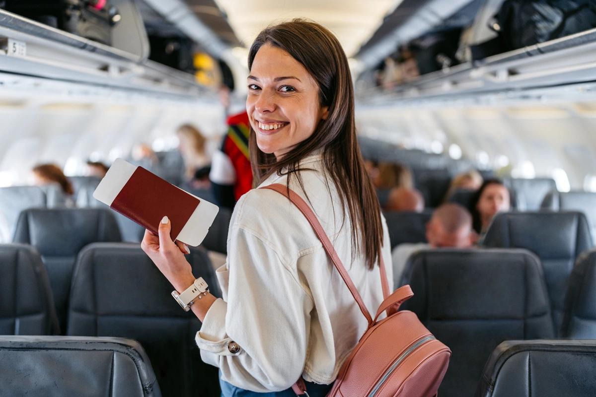 A happy female passenger finds her seat on a plane