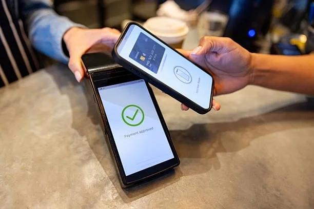 Image of someone checking out using contactless payment. Tap now, worry later? Why higher contactless limits could lead to overspending